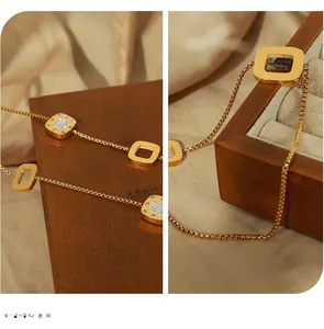 Detailed view of gold square pendants with inlaid diamonds on a sleek snake chain