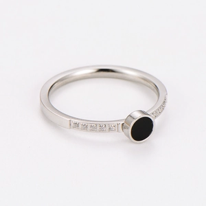 Gros plan d'une bague en acier argenté avec insert noir et petits détails en zircon