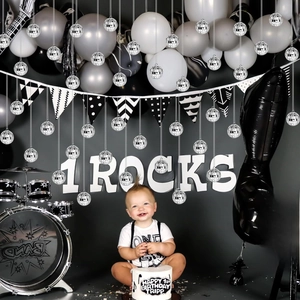 Close-up of Rock and Roll 1st birthday party set with disco balls and guitar balloons