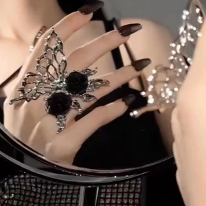 Gothic liquid metal butterfly ring with black roses in a stylish mirror reflection view