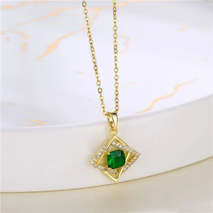 Macro shot of gold necklace with green square gemstone in a geometric pendant
