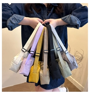 Dettaglio di borse a tracolla in nylon impermeabile dai colori pastello con cinghie regolabili