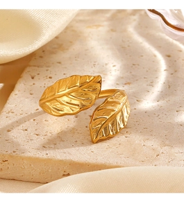 Macro detail of golden leaf ring with intricate veins on a textured stone display