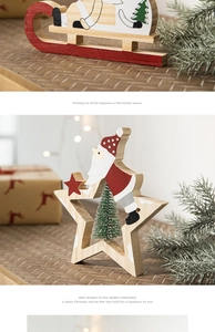 Détail de décors de Noël en bois avec Père Noël et traîneau sur une table de fête