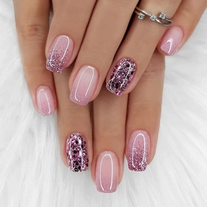 Pink gradient glitter press-on nails with purple sequins on white plush background