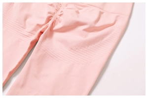 Detail of peach pink seamless yoga pants showing scrunch butt design and knit texture