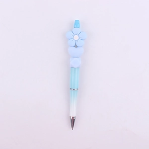Detail of beaded pen with light blue flower silicone topper and gradient blue barrel