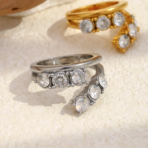 Vue détaillée des bagues double couche or et argent avec zircons sur fond de pierre