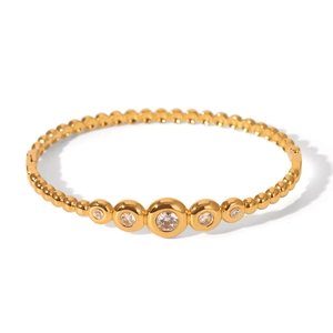 Polished gold beaded bangle featuring five symmetrical inset cubic zirconia stones