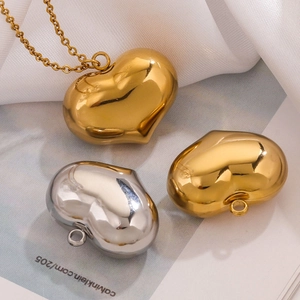 Polished heart pendant necklace set in gold and silver finish on silk fabric