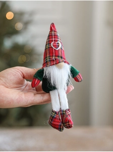 Detail of Christmas gnome plush with red plaid hat and long legs held in hand