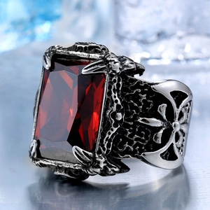 Macro detail of gothic men's ring with red rectangular gemstone and eagle claw setting