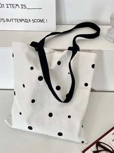 Minimalist canvas tote bag with black polka dots and shoulder straps for students