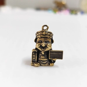 Détail macro du pendentif Dieu de la Richesse en laiton avec boulier et parchemin