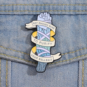Detail of creative sage enamel pin with funny slogan on blue denim jacket pocket