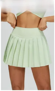 Detail of high-waist pleated tennis skirt in light green with elastic compression fabric