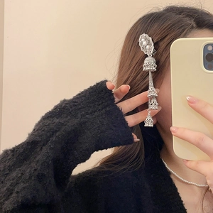 Detail of silver ethnic jhumka tassel hair clip with layered bell charms on model