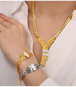 Detail of model wearing a chunky Y-necklace and cubic zirconia bracelets in gold and silver