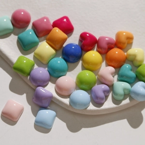 Detailed view of colorful macaron resin heart and round beads for DIY jewelry making