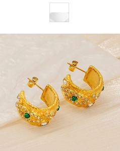 Gros plan sur boucles d'oreilles C dorées avec malachite verte et zircons incrustés