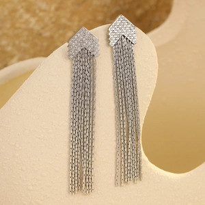 Macro detail of silver geometric tassel earrings with sparkling cubic zirconia on stand