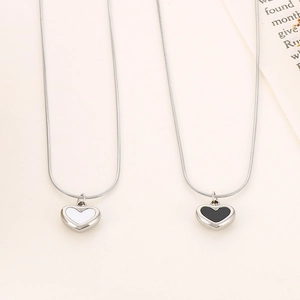Minimalist silver heart pendant necklaces with black and white centers on snake chains