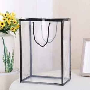 Detail of transparent PVC gift bag with black reinforced edges and woven handles