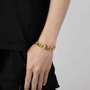 Close-up of a 13mm gold cuban link necklace worn as a wrap-style bracelet on a male wrist