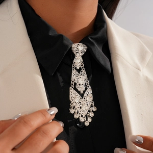 Macro shot of silver tassel necklace with geometric hollow design and rhinestones on suit