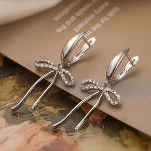 Macro shot of silver bow tassel earrings with micro-pave cubic zirconia crystals