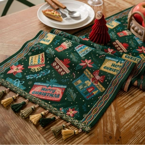 Detail of green Christmas table runner with Merry Christmas weaving and gold tassels