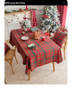 Detail of red and green plaid Christmas tablecloth with gold thread on festive dinner table