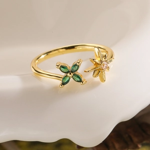 Macro detail of 18K gold flower ring featuring green marquise gems and white zircon