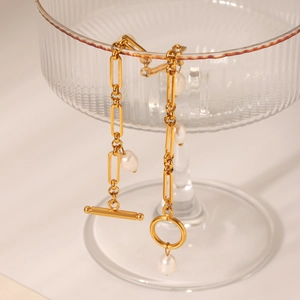 Detailed macro shot of 18K gold-plated chain bracelet with freshwater pearls and OT buckle