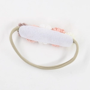 Detail of baby floral headband with pink and white flowers on elastic beige band