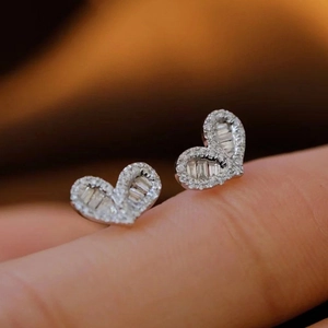 Minimalist heart-shaped stud earrings featuring a pave-set diamond halo and center mosaic stones