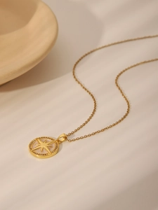 Detailed macro view of the gold necklace featuring an octagonal star pendant with zircons