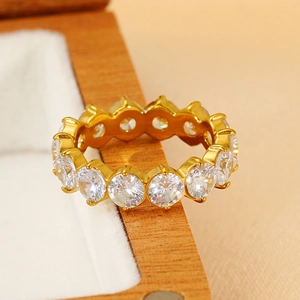 Detail of 18k gold eternity ring with circular cubic zirconia in a wooden jewelry box