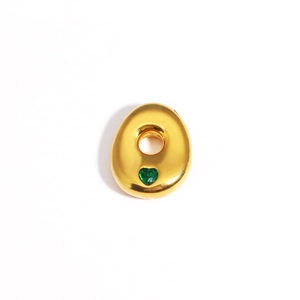 Détail d'un pendentif ovale doré orné d'une pierre précieuse vert émeraude en cœur