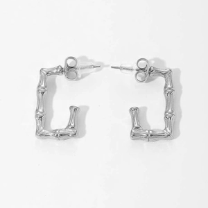 Macro view of C-shaped rectangular silver steel earrings with unique bamboo texture detail