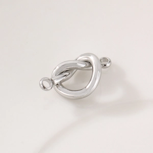 Macro detail of silver knot heart connector pendant with dual loops for DIY jewelry making
