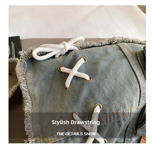 Close-up of light blue denim fabric with white cotton drawstring and frayed edges detail