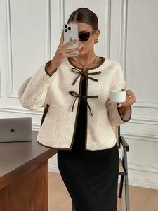 Détails de la texture laine d'agneau et des nœuds de serrage marron sur la veste