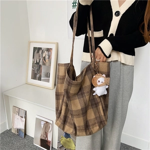 Large capacity plaid wool tote bag held by a model in a stylish lifestyle setting