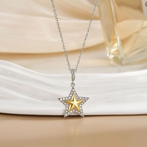 Star pendant necklace with silver diamond-set outer star and golden inner star detail