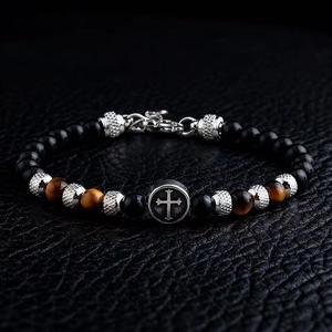 Detail of 6mm beaded bracelet with tiger eye stones and silver cross bead on black leather