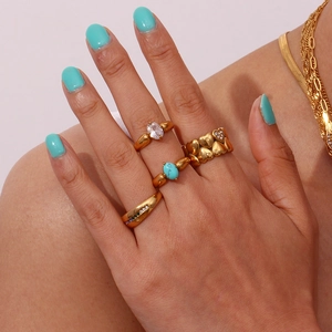 Detail of vintage gold stackable rings with turquoise, heart motif and zircon inlay