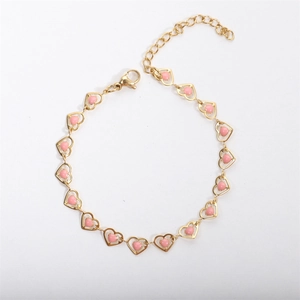 Macro shot of 18k gold plated heart bracelet featuring pink enamel charms and adjustable clasp