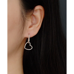 Detailed close-up of a silver S925 heart-shaped dangle earring worn by a model