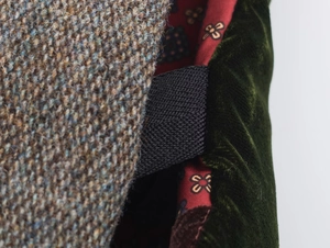 Macro detail of patchwork velvet, tweed texture and printed satin lining on a vest
